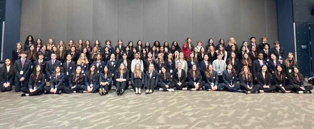 group of students posing in front of neutral background