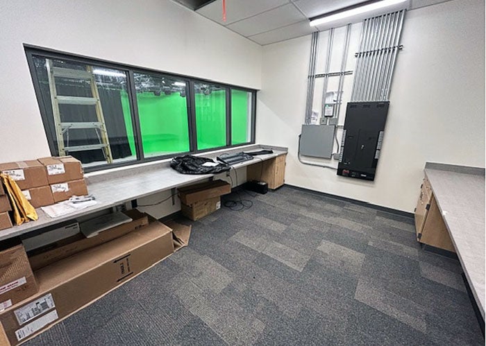 a room with counders on both sides and a window into a room with a green screen